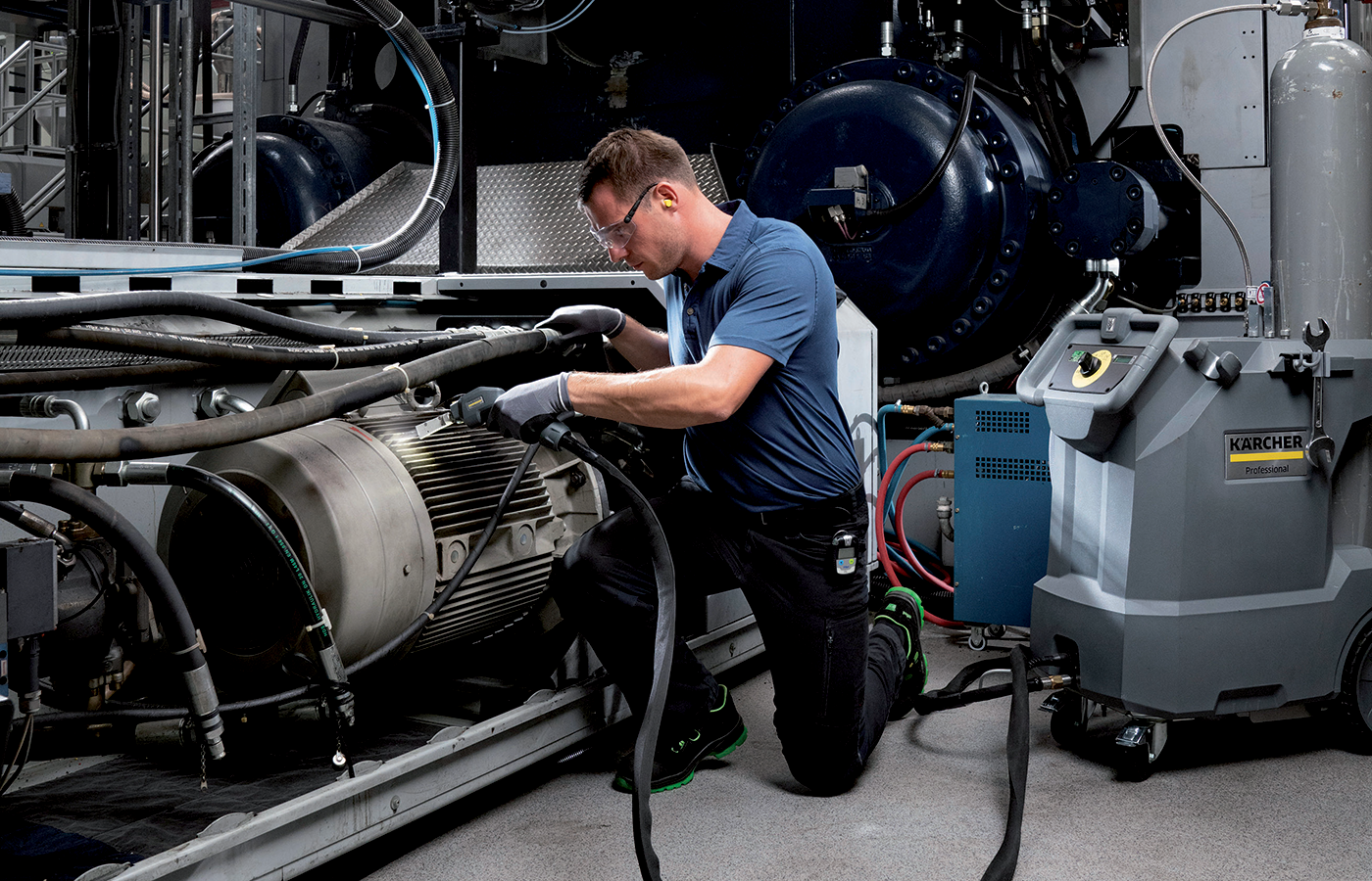 Technicien réalisant la maintenance d’une machine industrielle avec un équipement Kärcher professionnel.